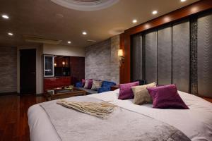 - une chambre avec un grand lit blanc et des oreillers violets dans l'établissement ホテル シードット 横浜 ドゥエ, à Yokohama