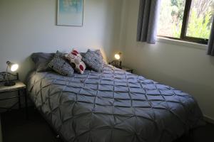 a bed in a bedroom with two tables and a window at Altona Garden Retreat in Spreyton