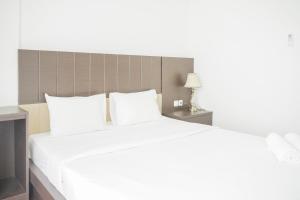 ein großes Bett mit weißen Laken und Kissen in der Unterkunft Exclusive Studio Room at Casa De Parco Apartment By Travelio in Samporo + 10 Fotos