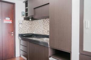 eine Küche mit Spüle und braunem Schrank in der Unterkunft Exclusive Studio Room at Casa De Parco Apartment By Travelio in Samporo