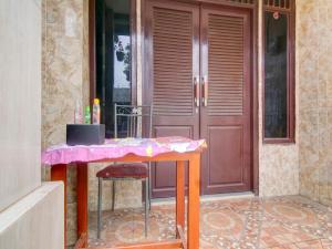 een tafel voor een deur met een roze tafel bij OYO 3863 Nakula Sadewa in Depok
