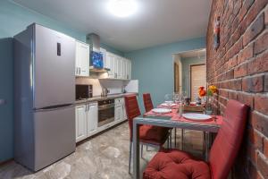 cocina con mesa y pared de ladrillo en Уютные Апартаменты RentPlaza в центре города 24x7 дистанционно en Samara