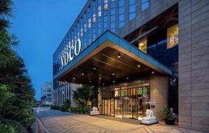 a building with a sign on the front of it at voco - Hangzhou Binjiang Minghao, an IHG Hotel in Hangzhou