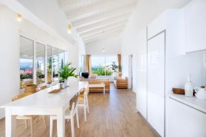 een witte keuken en eetkamer met een witte tafel en stoelen bij Almyrida Sands in Almirida
