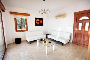 a living room with two white couches and a table at Villa Elina in Paphos City
