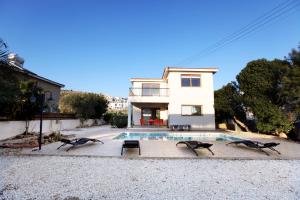 a house with a swimming pool in front of a house at Villa Elina in Paphos