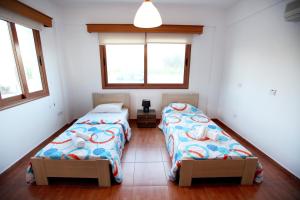 two beds in a small room with two windows at Villa Elina in Paphos City +25 photos