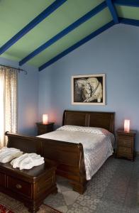 a bedroom with a bed with blue walls and two tables at Akti in Nafpaktos