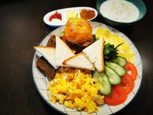 um prato de pequeno-almoço com torradas e legumes em Royal Petrol Hotel em Taldykorgan
