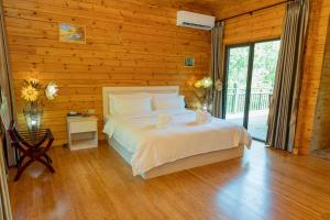 Un dormitorio con una cama y una pared de madera. en Dansavanh Namngum Resort, en Ban Keun 175 fotos más