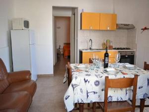 uma cozinha com uma mesa com uma toalha de mesa branca em Three-room holiday home with outdoor space and a few steps from the cliff em Torre dell'Orso