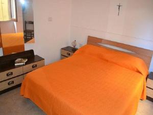 um quarto com uma cama laranja e um espelho em Three-room holiday home with outdoor space and a few steps from the cliff em Torre dell'Orso