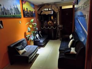 un bar con sofás de cuero negro en una habitación en Hostal Milagros, en Chancay