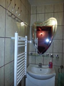 a bathroom with a sink and a mirror on the wall at Casuta Paterau Cheia, Prahova in Cheia
