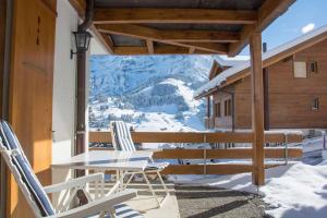 a table and chairs on a balcony with a view at Ferienwohnung Senggi in Adelboden
