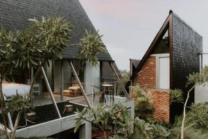 レンバンにあるvilla tibraのヤシの木が植えられた家の外観