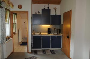 Una cocina con gabinetes azules y un fregadero. en Ferienwohnung Lanzinger inkl. Chiemgaukarte, en Ruhpolding
