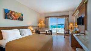 トゥルグトレイスにあるAzure By Yelken Hotelのベッド付きのホテルルームで、海の景色を望めます。