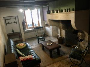 ein Wohnzimmer mit einem Sofa und einem Kamin in der Unterkunft Saint Gorgon Gite in Euville