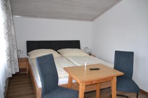 ニーダーンジルにあるFerienwohnung Höllwerthのベッドルーム1室(ベッド1台、テーブル、椅子付)
