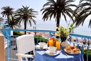 stół z jedzeniem i widokiem na plażę w obiekcie Residence Atlantic w Alassio