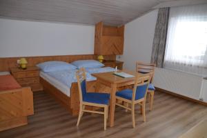 ニーダーンジルにあるFerienwohnung Höllwerthのベッドルーム1室(ベッド1台、テーブル、椅子付)
