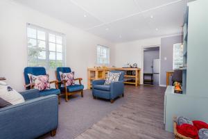 a living room with blue chairs and a table at Konings Cottage in Gansbaai