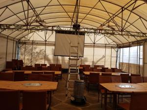 a large tent with tables and a screen in it at Jungmun Resort Jeju in Seogwipo