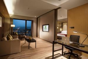 ein Hotelzimmer mit einem Schreibtisch und einem Schlafzimmer in der Unterkunft Holiday Inn Putian Xiuyu, an IHG Hotel in Putian
