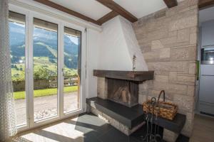 a living room with a fireplace and a large window at Ferienwohnung Helios in Adelboden