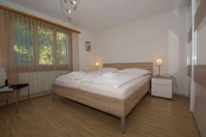 - une chambre avec un grand lit et une fenêtre dans l'établissement Ferienwohnung Helios, à Adelboden