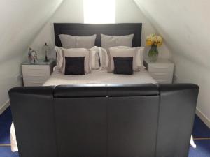 a large bed with a black headboard and white pillows at Carmichael in Edinburgh