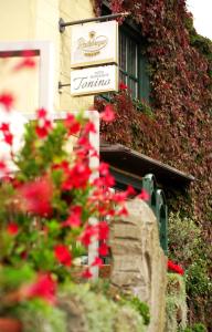 ein Schild an der Seite eines Gebäudes mit roten Blumen in der Unterkunft Hotel Restaurant Tonino in Bad Bentheim