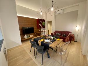 a living room with a table and chairs and a couch at Volto Corte Farina Apartments in Verona