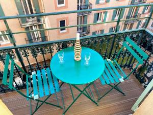 einen Tisch mit 2 Stühlen und eine Vase auf dem Balkon in der Unterkunft Sunny and calm 2 bed apartment place du Pin in Nizza