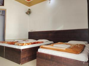 two beds sitting next to each other in a room at Hotel Vrindavan in Fatehpur Sīkri