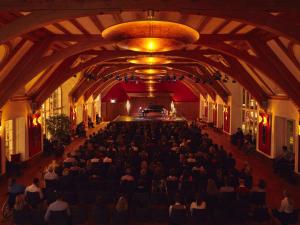 un gruppo di persone seduti in una sala con un pianoforte di Schloss Elmau Luxury Spa Retreat & Cultural Hideaway a Elmau