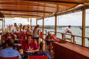 a group of people sitting at tables on a boat at Alojamiento Lo Trabucador in Poblenou del Delta