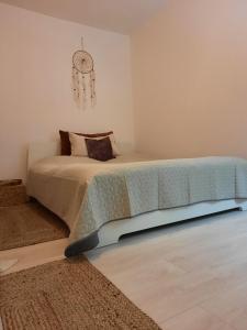 1 dormitorio con 1 cama y reloj en la pared en Cocooning in a Lovely Mountain suite - Two, en Azuga