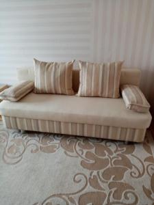 a couch sitting in a living room with pillows at Пинск ул. Центральная 3A-MANGO in Galevo