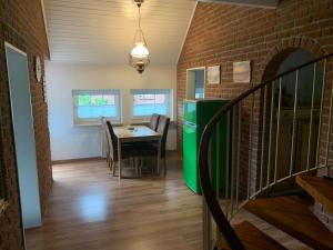 een eetkamer met een tafel en een bakstenen muur bij Ferienhaus Schonerweg 9 in Norddeich in Norddeich