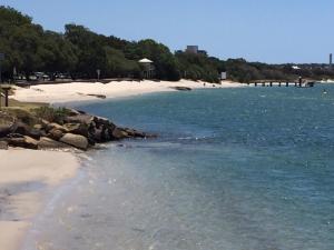 uma praia com água azul e uma praia arenosa em Just Perfect Apartment with Ocean Views em Caloundra