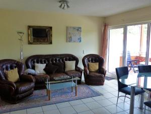 a living room with two leather couches and a table at Apartments Haus Düneneck - Dietmar Opel in Zempin