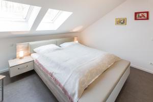 um quarto com uma cama branca e uma janela em Ferienwohnung Meeresrauschen em Ostseebad Sellin