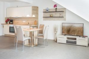 een keuken met een tafel en stoelen en een televisie bij Ferienwohnung Meeresrauschen in Ostseebad Sellin