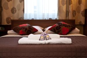 a bed with two towels and pillows on it at Hotel Maksymilian in Krakow