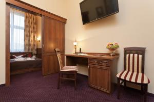 a room with a desk and two chairs and a bed at Hotel Maksymilian in Krakow
