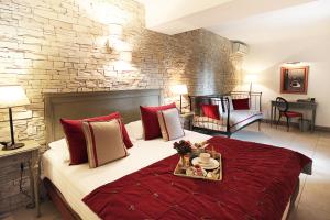 ル・ルレにあるHôtel du Closのベッドルーム1室(赤いベッドカバー付きの大型ベッド1台付)