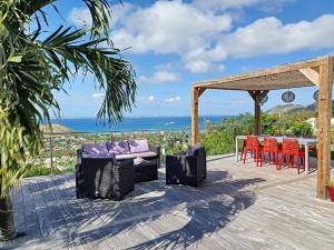 una terraza con mesa, sillas y el océano en Villa SEA VIEW, 5 min from the beach, overlooking the caribbean sea, private pool, en Friar's Bay