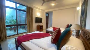 a bedroom with two beds and a large window at The Stay Inn New Delhi in New Delhi